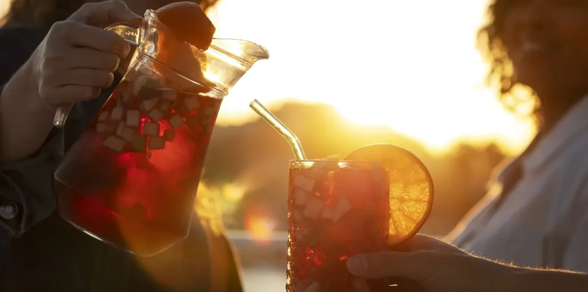 Buy best refreshing drinks online in India – chilled fruit beverage served in a glass with fresh citrus garnish during a relaxing outdoor gathering.
