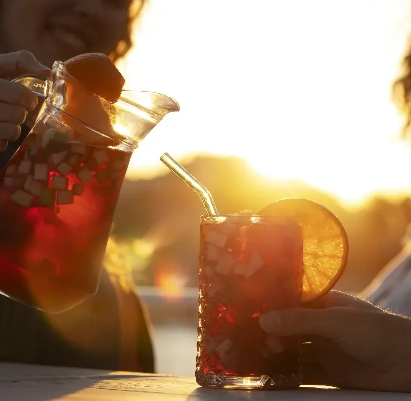 Buy best refreshing drinks online in India – chilled fruit beverage served in a glass with fresh citrus garnish during a relaxing outdoor gathering.