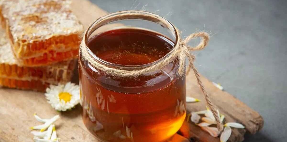 Buy Pure Honey Online in India – jar of pure honey with honeycomb and flowers