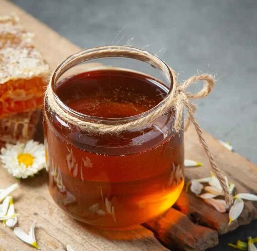 Buy Pure Honey Online in India – jar of pure honey with honeycomb and flowers